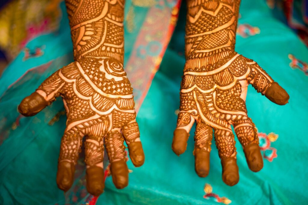 Bridal mehendi design being applied to a client's hand