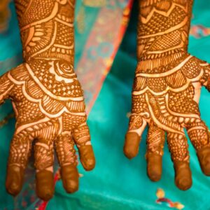 Bridal mehendi design being applied to a client's hand